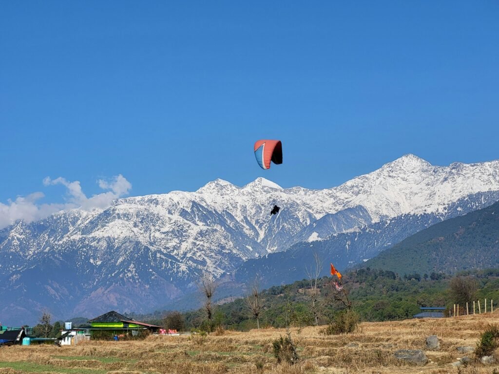 pexels-photo-20137380-20137380 Paragliding adventure over the scenic snowy mountains of Bir, India, under a clear blue sky.